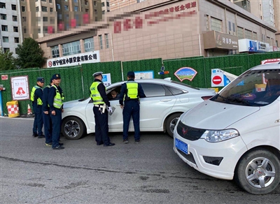 图为交警联合运管执法部门,在祁连路锦绣江南小区门口查扣非法营运